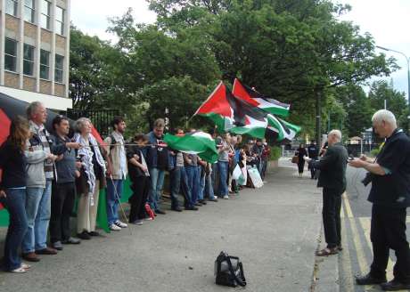 Click on image to see full-sized version Protesters wall off the embassy gate, while Diarmuid recites his poem.